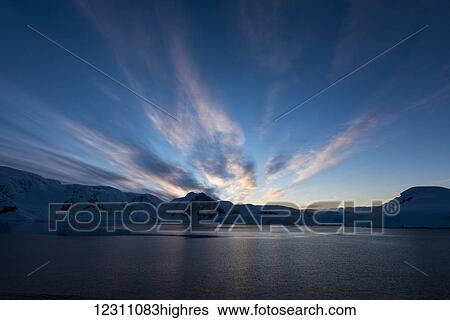 Stock Photograph - Simultaneous sunrise and sunset; Antarctica. Fotosearch