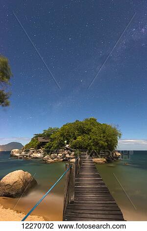 Stock Image - Small bridge going from Mumbo Island to small island for tourist's accommodation under a starry sky, Lake Malawi; Malawi. Fotosearch