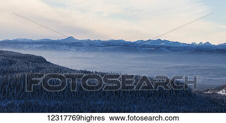 Stock Photograph - Snow covered landscape of the rugged Canadian Rockies and a forest in winter; British Columbia, Canada. Fotosearch