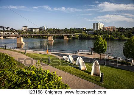Stock Photograph - South Saskatchewan River with bridge and promenade; Saskatoon, Saskatchewan, Canada. Fotosearch