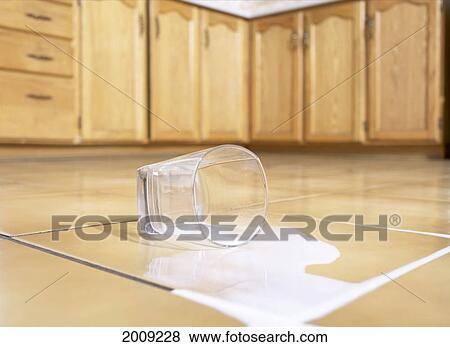 Stock Photo - Spilled Glass Of Milk On Tile Floor. Fotosearch