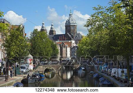 Stock Photo - St. Nicolas Church in the background with canal in foreground; Amsterdam, Holland. Fotosearch