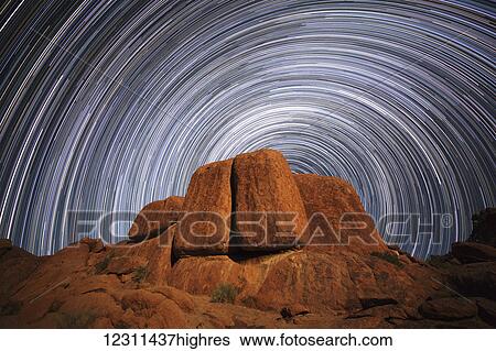 Stock Photograph - Star trails above a large boulder in Richtersveld National Park; South Africa. Fotosearch