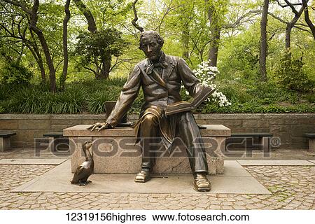Stock Photograph - Statue of Hans Christian Anderson sitting on a bench reading a book in Central Park; New York City, New York, United States of America. Fotosearch
