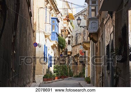 Stock Image - Street Scene Featuring Houses With Enclosed Balconies, Vittoriosa (Birgu), Malta. Fotosearch