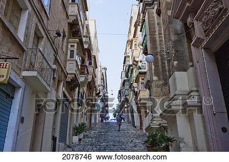 Stock Photograph - Street Scene Featuring Stairs And Buildings With Enclosed Balconies, Valletta, Malta. Fotosearch
