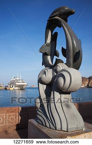 Stock Photo - Sultan Qaboos royal yacht and dolphin statue, Mutrah harbour; Mutrah, Muscat, Oman. Fotosearch