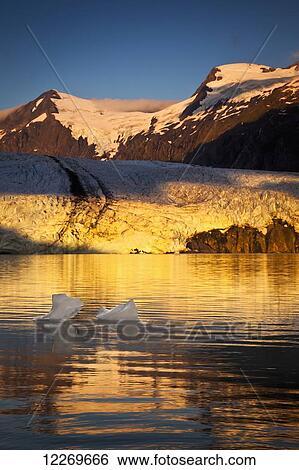 Stock Photograph - Sunrise view of Portage Glacier with icebergs and Byron Peak in the background, Chugach National Forest, Kenai Peninsula, Southcentral Alaska, Summer.. Fotosearch