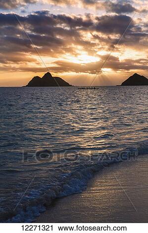Stock Image - Sunset at Lanikai Beach, with Mokuluas islands in the background; Oahu, Hawaii, United States of America. Fotosearch