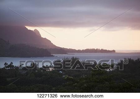 Stock Photograph - Sunset over Hanalei Bay and Haena (in distance) from Hanalei Valley lookout; Hanalei, Kauai, Hawaii, United States of America. Fotosearch