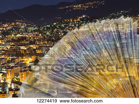 Stock Photo - Swiss franc notes illuminated in colour with the cityscape at nighttime in the background; Lugano, Ticino, Switzerland. Fotosearch