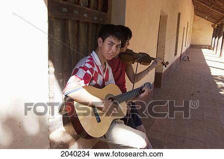 Picture - Teenage Boys Playing A Violin And A Guitar At The Jesuit Mission Of Santa Ana De Velasco, Santa Cruz Department, Bolivia. Fotosearch