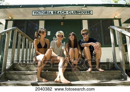 Stock Image - Teenagers Sitting Outside Laughing, Victoria Beach, Manitoba. Fotosearch