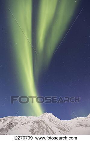 Stock Photo - The Aurora Borealis (Northern Lights) dancing over the Brooks Range on the south side of Atigun Pass, Arctic Alaska, Winter. Fotosearch