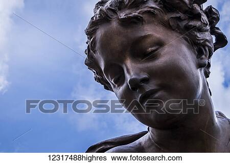 Stock Photograph - The beautiful face of a female statue made of bronze; Paris, France. Fotosearch