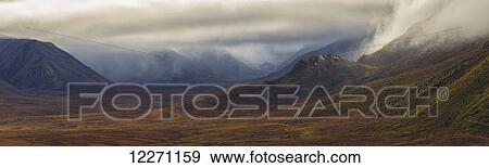 Stock Photo - The Blackstone Valley along the Dempster Highway is shrouded in clouds in autumn; Yukon, Canada. Fotosearch