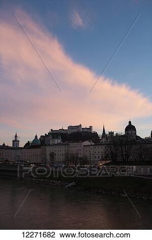 The historic centre and castle seen from the Salzach river at dusk with a pink cloud; Salzburg, Austria View Large Photo Image Stock Image - The historic centre and castle seen from the Salzach river at dusk with a pink cloud; Salzburg, Austria. Fotosearch