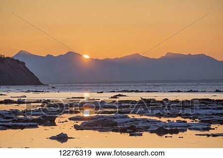 The setting sun is reflected on the icy waters of Cook Inlet, Point Woronzof in the background, Anchorage, Southcentral Alaska, Winter View Large Photo Image Stock Photo - The setting sun is reflected on the icy waters of Cook Inlet, Point Woronzof in the background, Anchorage, Southcentral Alaska, Winter. Fotosearch
