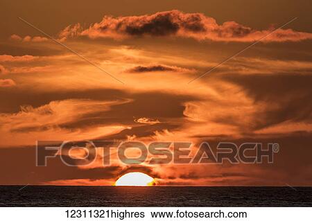 Stock Photograph - The setting sun observed from the Kona coast; Kona, Island of Hawaii, Hawaii, United States of America. Fotosearch