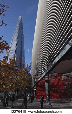 Stock Photo - The Shard skyscraper by Renzo Piano on the South Bank seen behind other nearby new office buildings with autumn coloured trees; London, England. Fotosearch