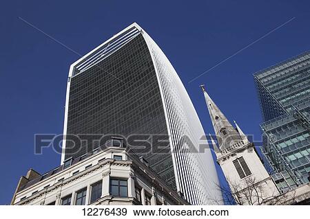 The Walkie Talkie building, 20 Fenchurch Street, designed by Rafael Vinoly with the spire of Christopher Wren's Church St Margaret Pattens; London, England View Large Photo Image Stock Photo - The Walkie Talkie building, 20 Fenchurch Street, designed by Rafael Vinoly with the spire of Christopher Wren's Church St Margaret Pattens; London, England. Fotosearch
