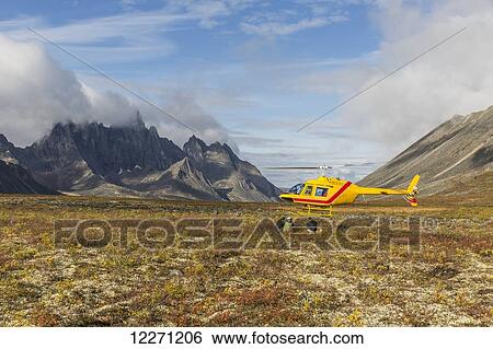 Three men get out of a helicopter on a mountain top in Tombstone Territorial Park; Yukon, Canada View Large Photo Image Stock Photograph - Three men get out of a helicopter on a mountain top in Tombstone Territorial Park; Yukon, Canada . Fotosearch