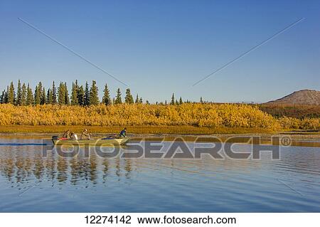 Three People in a skiff drive down the Noatak River with colorful willows along the riverbank, Noatak, Arctic Alaska, USA, Fall View Large Photo Image Stock Image - Three People in a skiff drive down the Noatak River with colorful willows along the riverbank, Noatak, Arctic Alaska, USA, Fall. Fotosearch