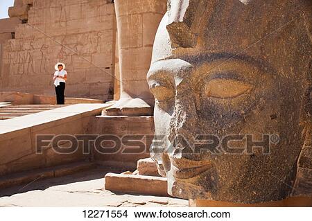 Picture - Tourist and carved head of Ramesses II, Ramesseum funerary temple, West Bank; Luxor, Egypt. Fotosearch
