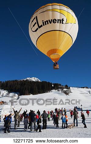Tourists, children and locals watch as a hot air balloon rises into the air at the ski resort's annual Balloon Week festival; Filzmoos, Austria View Large Photo Image Stock Photography - Tourists, children and locals watch as a hot air balloon rises into the air at the ski resort's annual Balloon Week festival; Filzmoos, Austria. Fotosearch