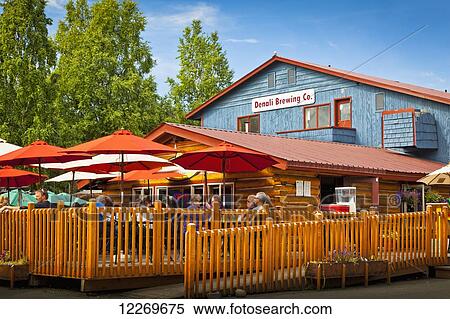 Tourists dining on the outdoor deck of Denali Brewing Company and Twister Creek Restaurant, Talkeetna, Southcentral Alaska, Summer. View Large Photo Image Stock Photography - Tourists dining on the outdoor deck of Denali Brewing Company and Twister Creek Restaurant, Talkeetna, Southcentral Alaska, Summer.. Fotosearch
