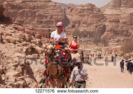 Tourists on camels riding along the colonnaded street; Petra, Jordan View Large Photo Image Stock Photograph - Tourists on camels riding along the colonnaded street; Petra, Jordan. Fotosearch