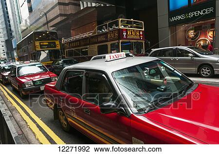 Stock Image - Traffic jam in Central district with tourist buses, red taxis and cars; Hong Kong Island, China. Fotosearch