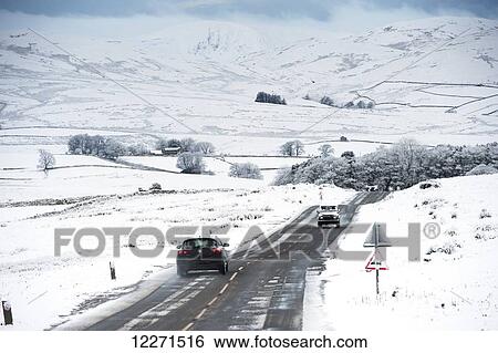 Stock Photograph - Traffic on the A683 between Kirkby Stephen and Sedbergh in snowy weather conditions; Cumbria, England. Fotosearch