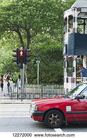 Stock Image - Tram and taxi waiting for the green light; Hong Kong, China. Fotosearch