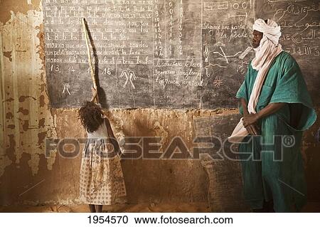 Tuareg teacher and girl in front of a blackboard at a primary school in Tiriken, Mali View Large Photo Image Stock Image - Tuareg teacher and girl in front of a blackboard at a primary school in Tiriken, Mali. Fotosearch