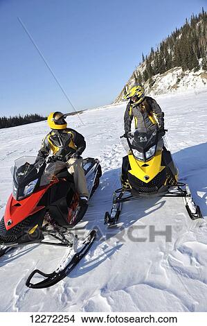 Picture - Two friends snowmachine near the Delta River north of the Alaska Range between Delta Junction and Fairbanks in Interior Alaska. Fotosearch