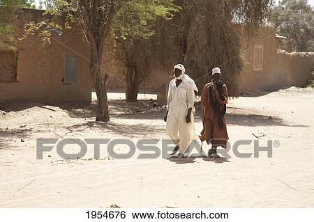 Two men walking on street in Niafunke, Mali View Large Photo Image Stock Photograph - Two men walking on street in Niafunke, Mali. Fotosearch