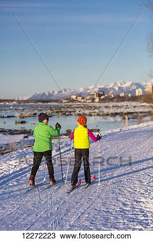 Two people cross country skiing on the Tony Knowles Coastal Trail with Anchorage in the background, Southcentral Alaska View Large Photo Image Stock Image - Two people cross country skiing on the Tony Knowles Coastal Trail with Anchorage in the background, Southcentral Alaska. Fotosearch