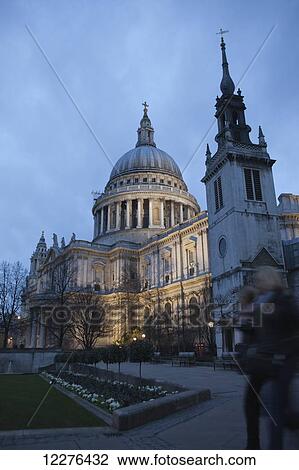 Stock Image - Two people walking past St. Paul's Cathedral at dusk; London, England. Fotosearch