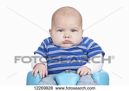 Stock Photo - Unhappy, healthy, chubby male infant enduring having his picture taken. Fotosearch