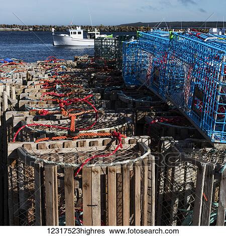 Stock Photograph - Various fishing traps on the shore of the harbour, Cape Breton Island; Main-a-dieu, Nova Scotia, Canada. Fotosearch