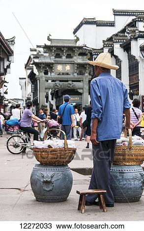 Vendor selling food on a busy street in a small village near Wuyuan; Jiangxi province, China View Large Photo Image Stock Image - Vendor selling food on a busy street in a small village near Wuyuan; Jiangxi province, China. Fotosearch