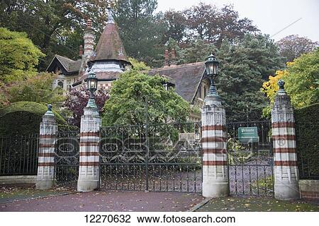 Stock Image - View of entrance and gatehouse to this famous home of Beatle George Harrison; Hanley-on-thames, Oxfordshire, England. Fotosearch