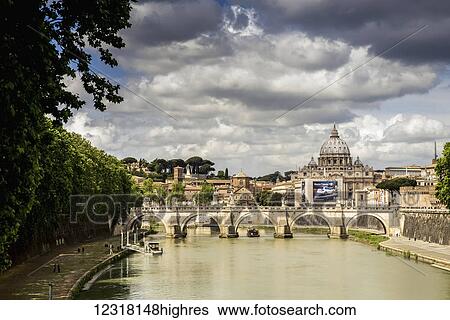 Stock Photograph - View of St. Peter's Basilica in the distance with a bridge and modern car advertisement over the Tiber River; Rome, Italy. Fotosearch
