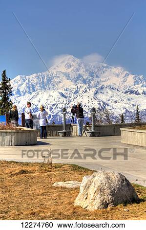 Stock Image - Visitors viewing the south side of Mt. Mckinley and Alaska Range from Denali Viewpoint South along the Parks Highway, Denali State Park, Spring, Southcentral, Alaska, HDR. Fotosearch