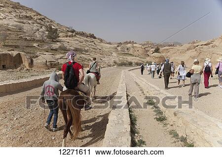 Stock Image - Walking and riding into the site; Petra, Jordan. Fotosearch