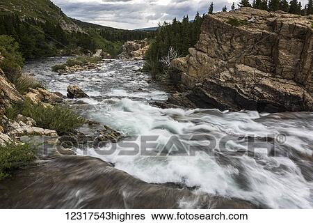 Stock Photograph - Water rushing down a river in Glacier National Park; Montana, United States of America. Fotosearch