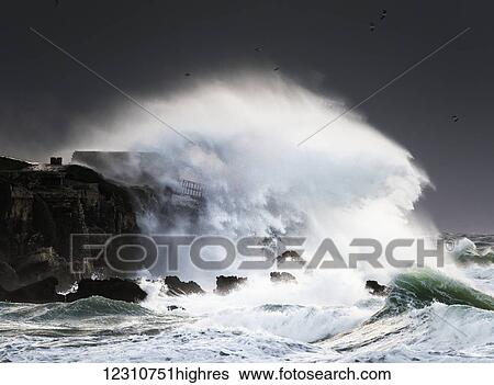 Wave crashing into shore and splashing onto the land above the cliffs, Isla de la Palomas; Tarifa, Cadiz, Andalusia, Spain View Large Photo Image Stock Photograph - Wave crashing into shore and splashing onto the land above the cliffs, Isla de la Palomas; Tarifa, Cadiz, Andalusia, Spain. Fotosearch