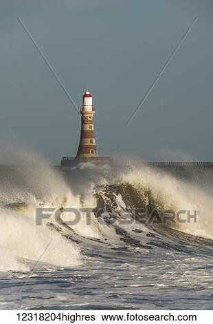 Stock Photograph - Waves breaking and Roker Pier Lighthouse; Sunderland, Tyne and Wear, England. Fotosearch