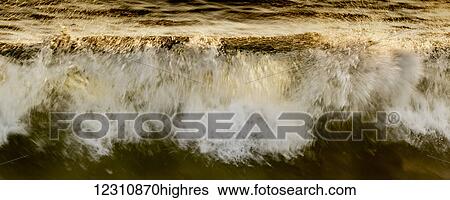 Waves breaking at the shore reflecting golden sunlight; Hawaii, United States of America View Large Photo Image Stock Photograph - Waves breaking at the shore reflecting golden sunlight; Hawaii, United States of America. Fotosearch